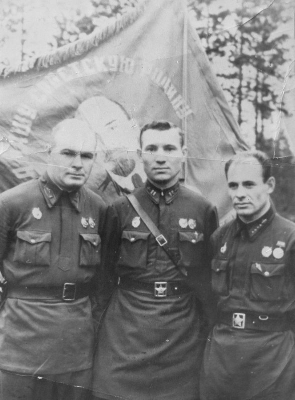 П.И.Семак (слева) с боевыми товарищами у развернутого гвардейского знамени полка.